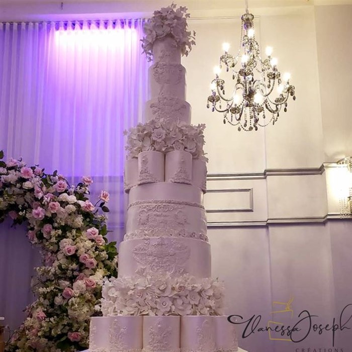 Very tall all white wedding cake  with white flowers tiers
