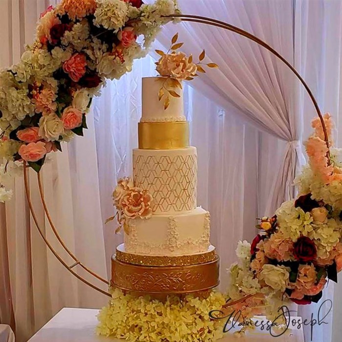 White and gold wedding cake with pink flowers