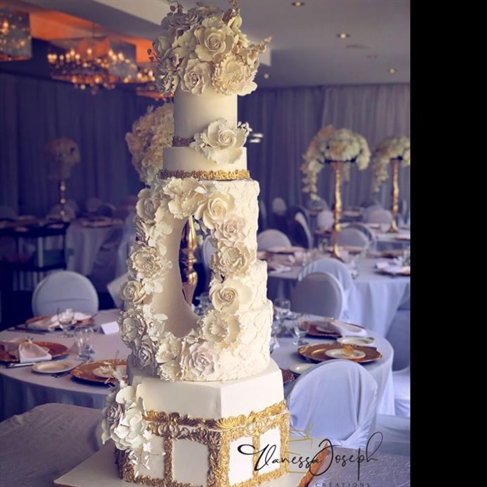 Extravagant white and gold wedding cake with a hole in the middle