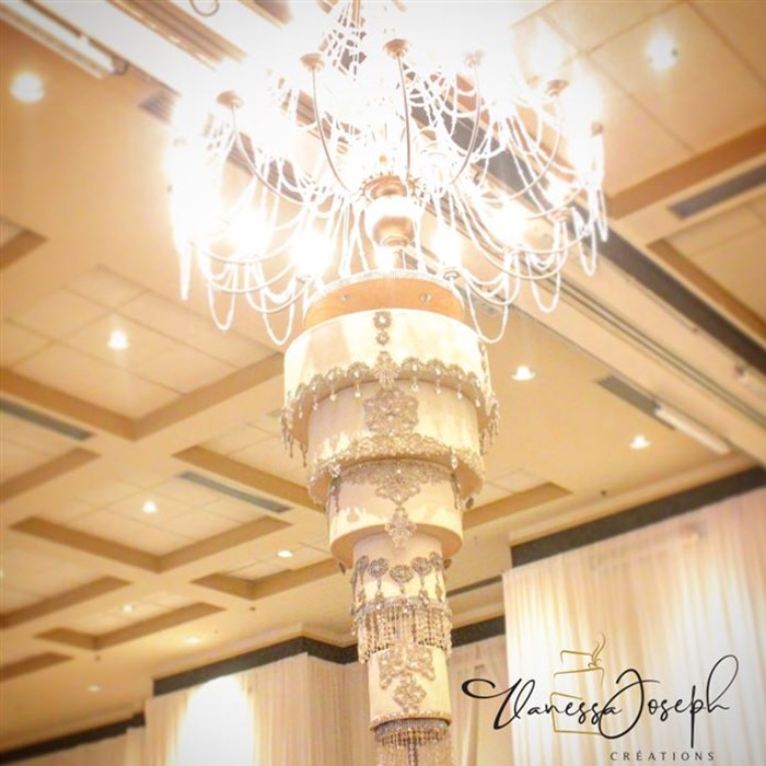 Upside down white and diamant wedding cake hanging from a chandelier