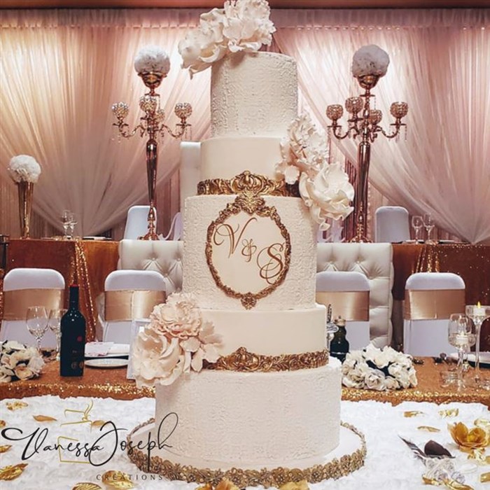  white and gold wedding cake with white flowers
