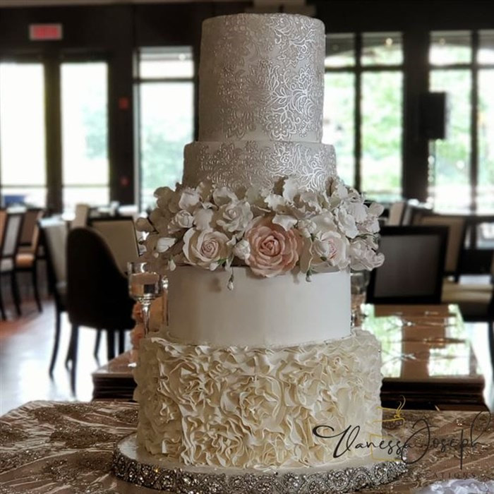 white and cream wedding cake with lace and flowers