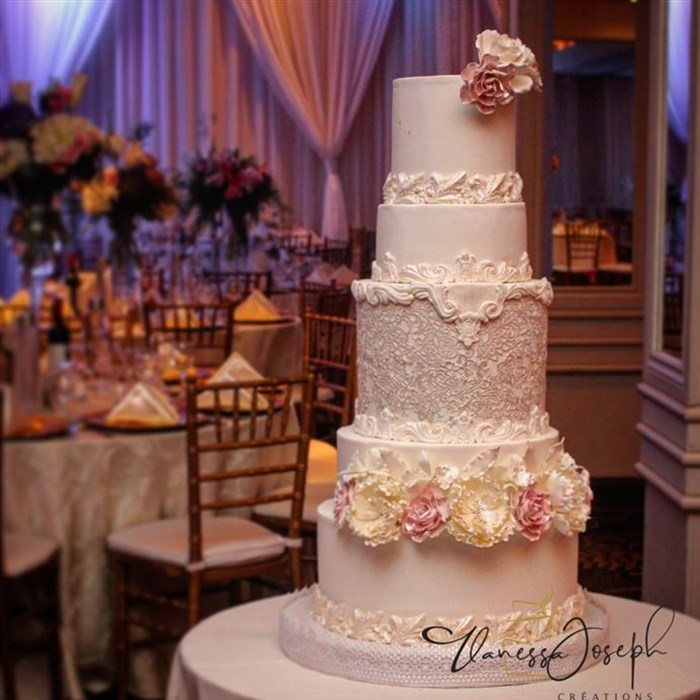 white wedding cake with lace and flowers