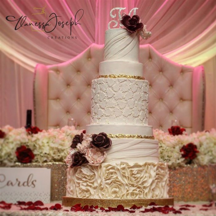 romantic white and gold wedding cake with pink and burgundy flowers