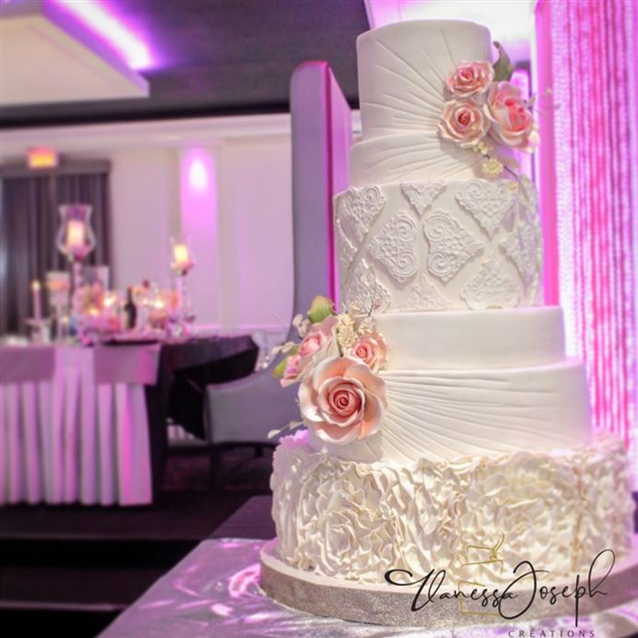 Textured white wedding cake with pink flowers