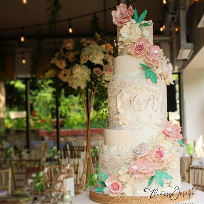 Garden white wedding cake with pink and white flowers and green leaves