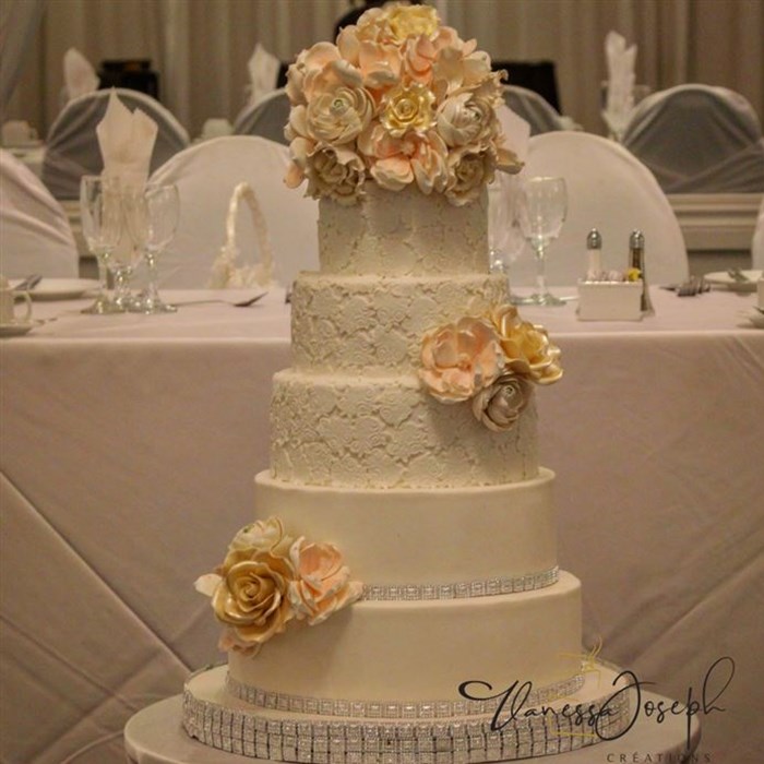 romantic white wedding cake with lace and pastel colors flowers