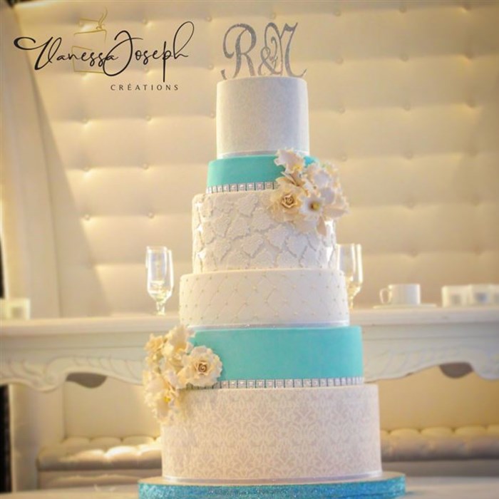 white and turquoise wedding cake with white and yellow flowers
