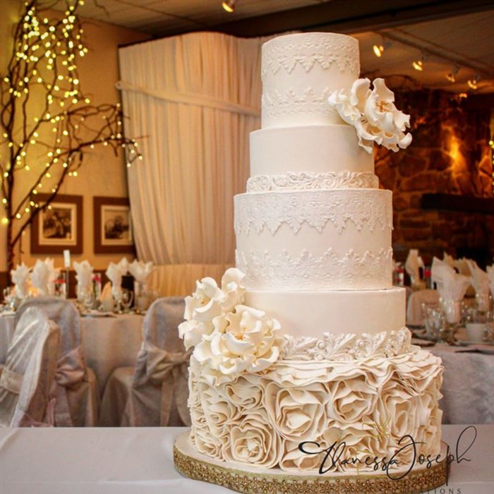 romantic white wedding cake with lace and flowers