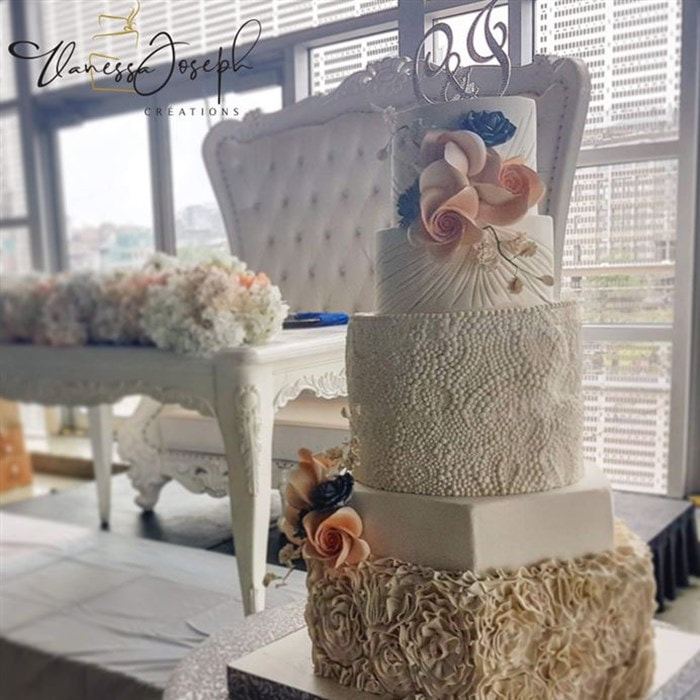 white wedding cake with peach and royal blue flowers 