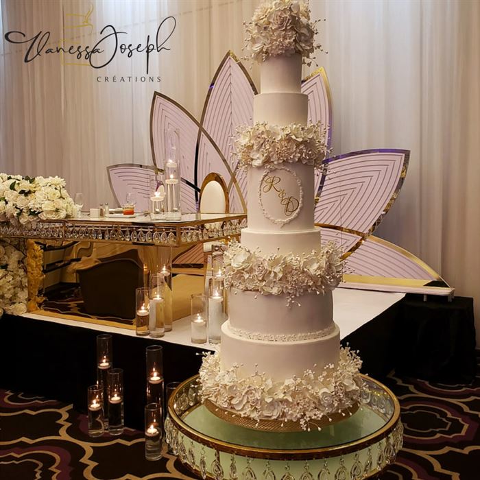 gâteau de mariage blanc avec étages de fleurs blanches
