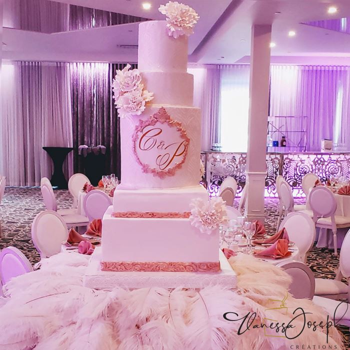 gâteau de mariage de différentes formes blanc et or rose, sur plumes blanches