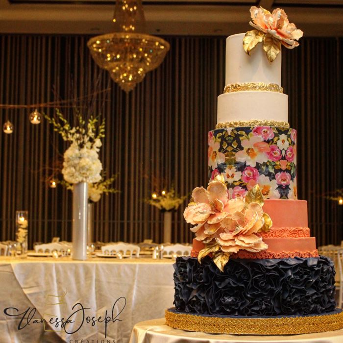gâteau de mariage moderne blanc, saumon, bleu marin et or avec des motifs de fleurs