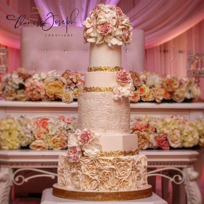 gâteau de mariage romantique blanc, or et rose avec beaucoup de fleurs