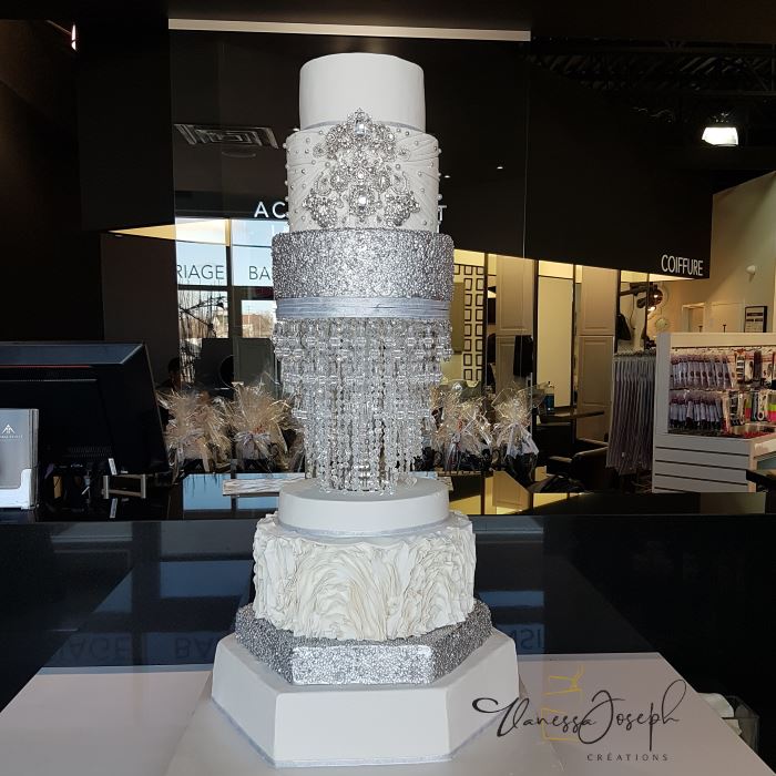 gâteau de mariage blanc et argent avec chandelier intégré et broches argentés