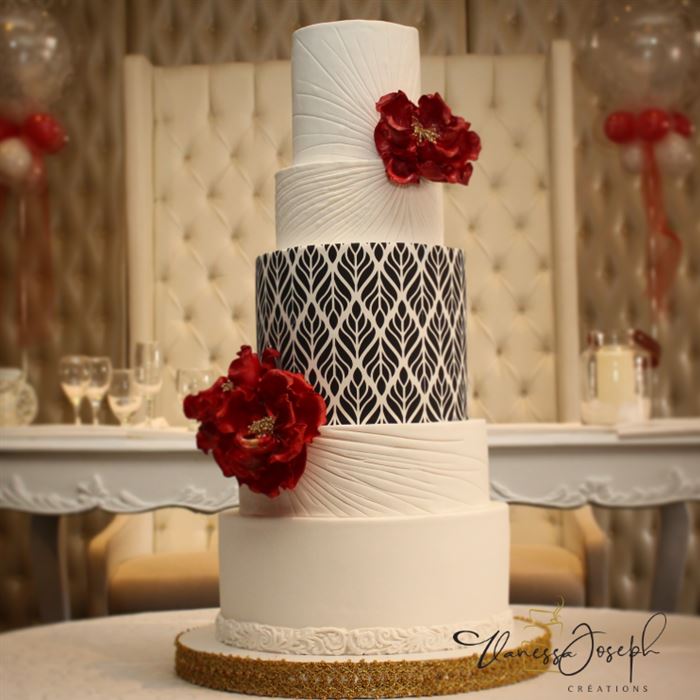 gâteau de mariage blanc, avec motif noir et blanc et fleurs rouges vif