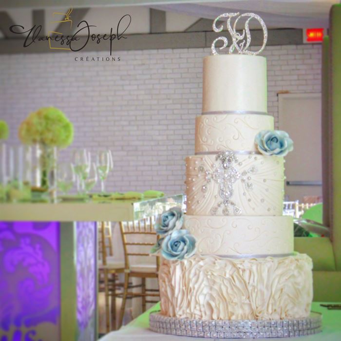 gâteau de mariage blanc et fleurs bleues avec bijoux argentés