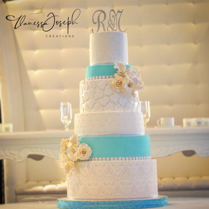 gâteau de mariage blanc et bleu turquoise avec fleurs blanches et jaunes