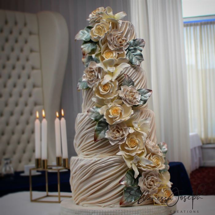 gâteau de mariage blanc avec drapé et cascade de fleurs blanches et jaunes
