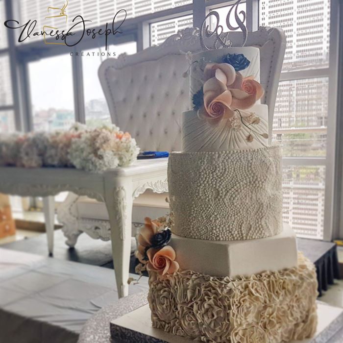gâteau de mariage blanc de formes différentes avec fleurs pêche et bleu royal