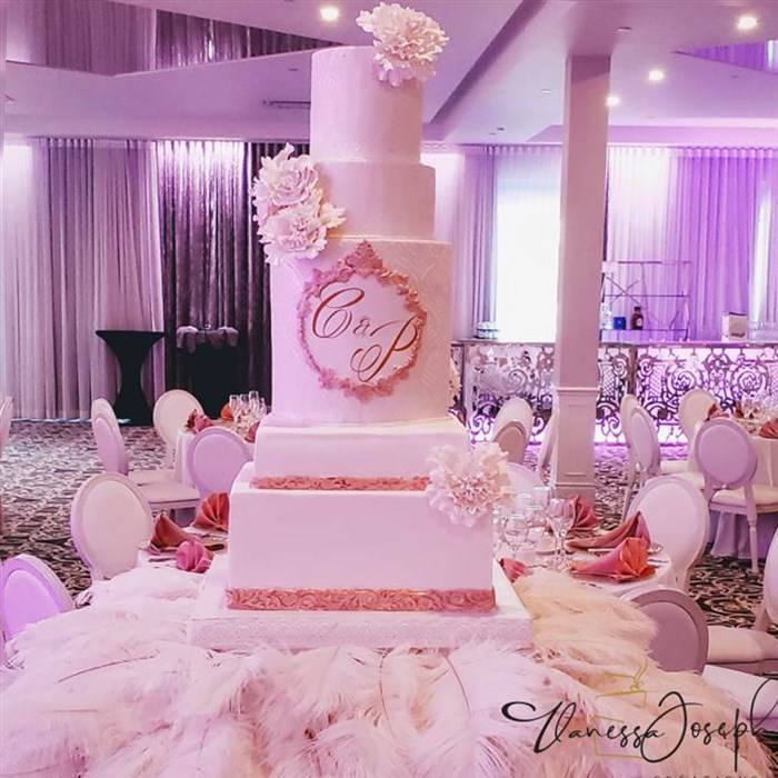 White and rose gold wedding cake on white feathers