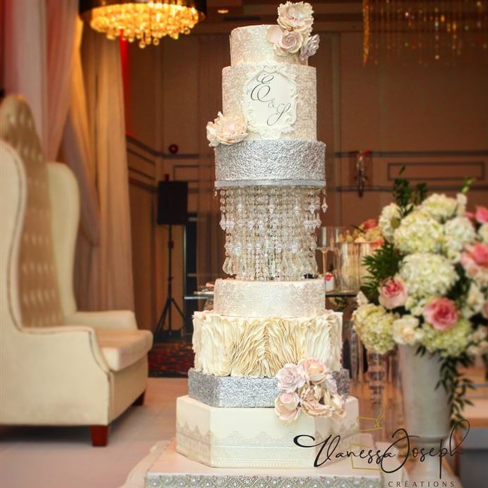 white and silver wedding cake with integrated chandelier